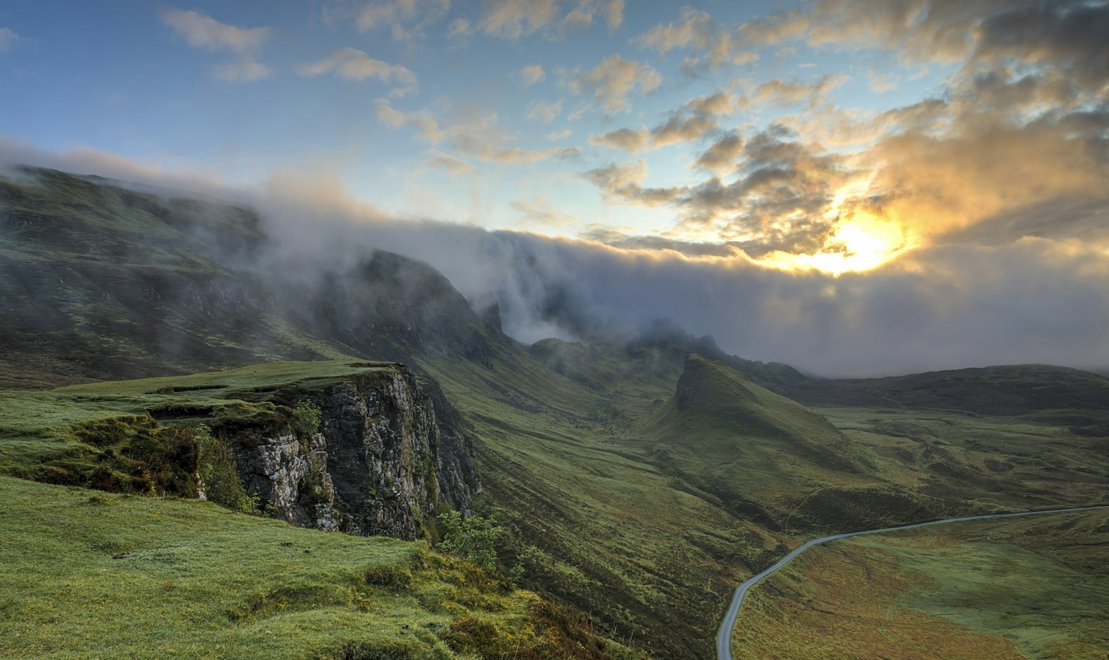 Clouds drifting over a quiet green mountain landscape